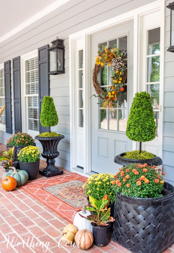 front porch decor ideas for fall with mums, pumpkins and a fall wreath