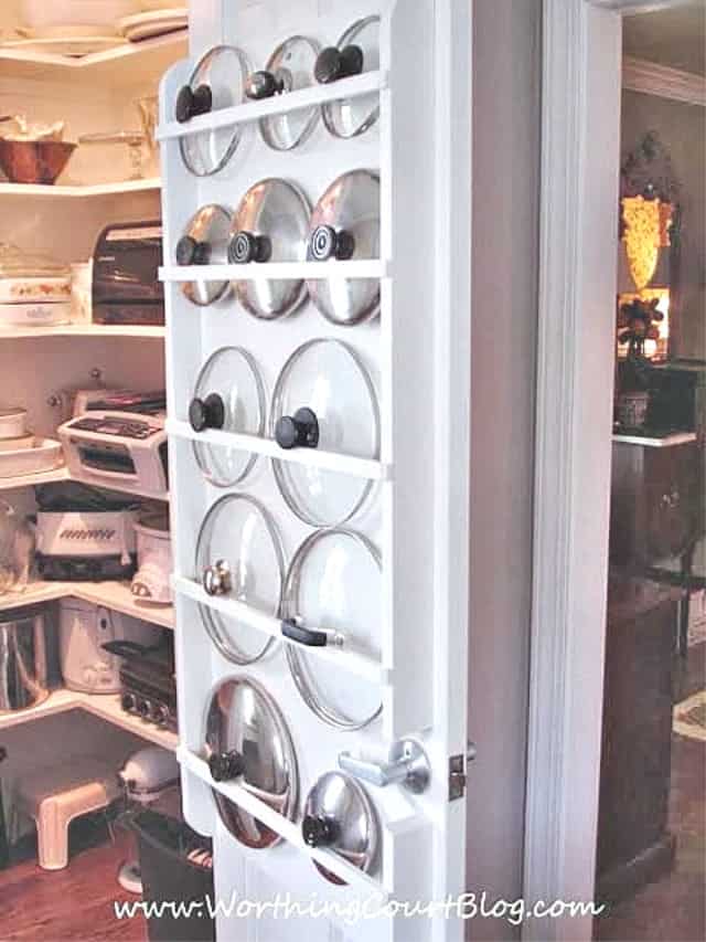 Pot lids stored on the back of a pantry door.