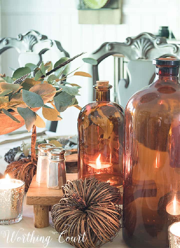 brown glass jugs and silver salt and pepper shakers in a Thanksgiving centerpiece