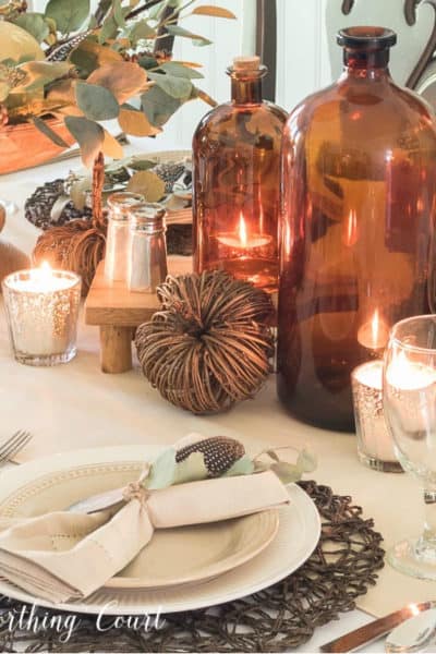 Thanksgiving table set with brown jugs and neutral dinnerware and linens