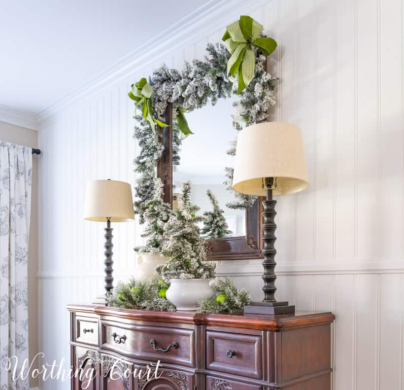 There is a garland on the mirror on the wall above the sideboard.