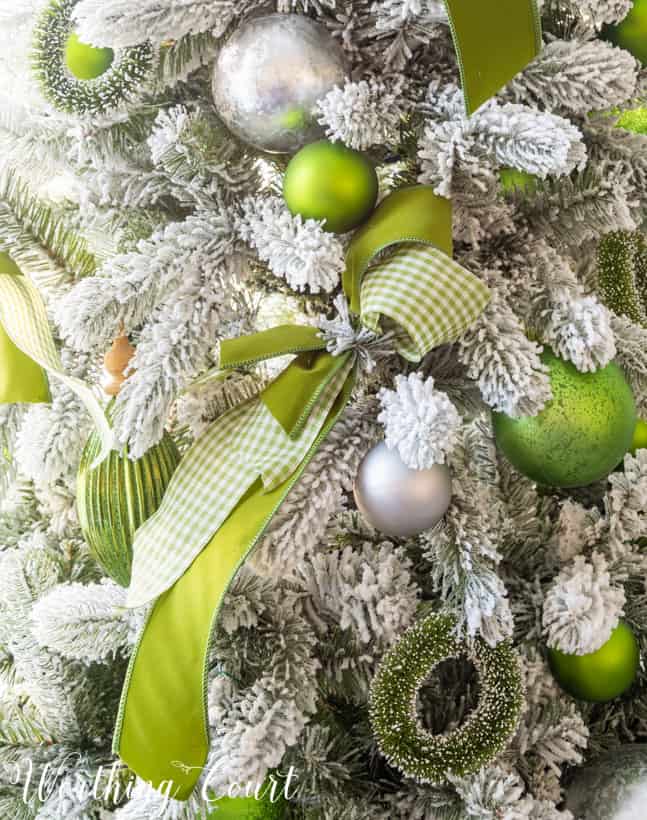 Up close picture of the green and silver ornaments on the tree.