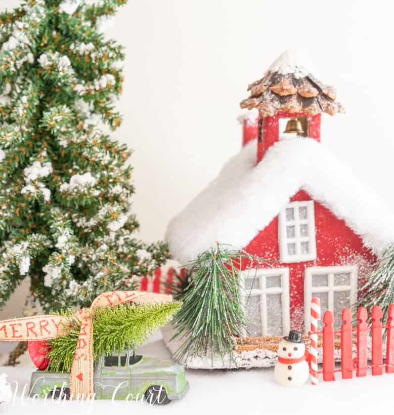 Red Christmas village house on a bed of snow.