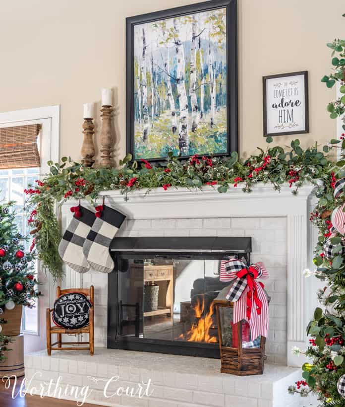 There are black and white buffalo checked stockings hanging by the fireplace.