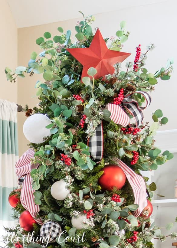 A large red star is on the top of the Christmas tree.