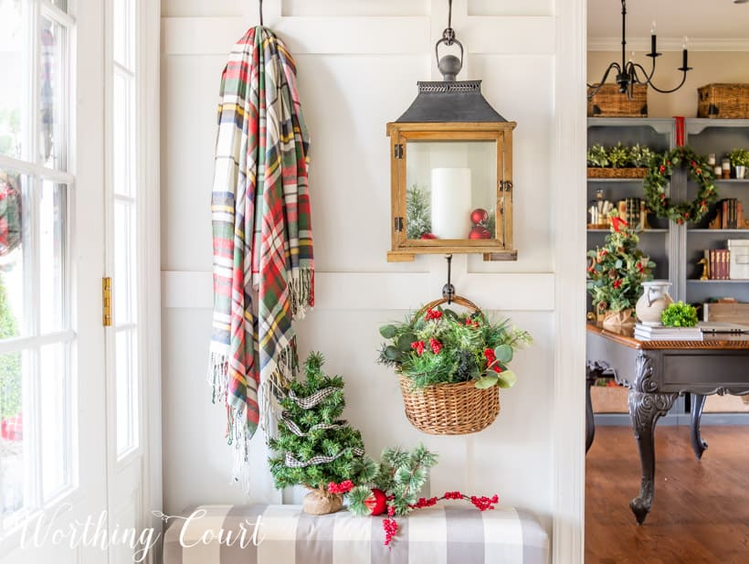 There is a lantern with a candle hanging from the wall in the entryway.