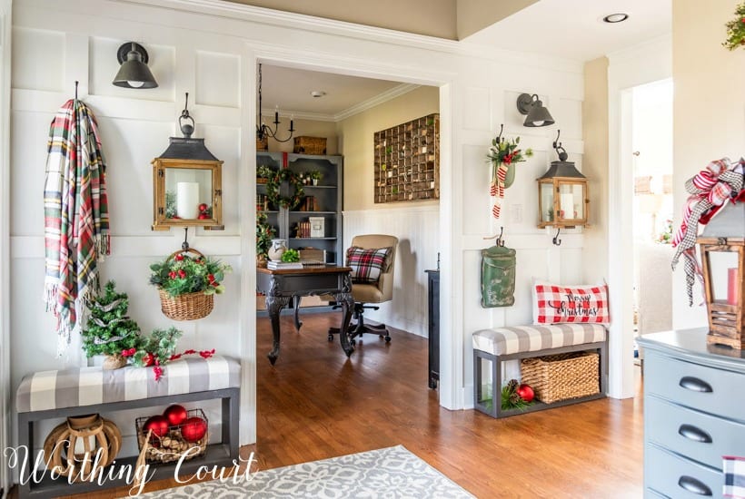 wall in foyer with Christmas decorations hanging on hooks