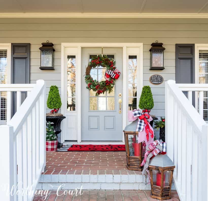 There are large lanterns with candles on the front porch and steps.