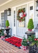 Front porch decorated for Christmas with red, black and white decor