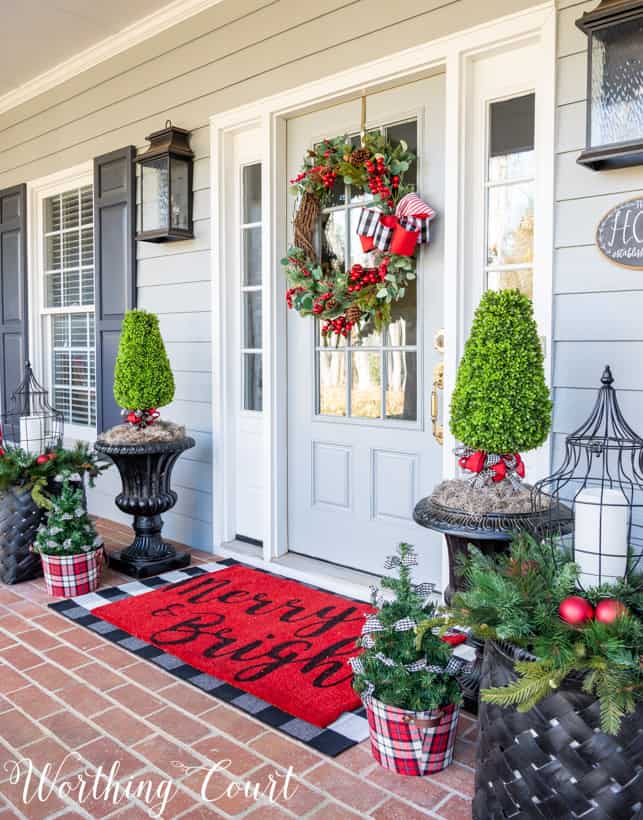 Front porch decorated for Christmas with red, black and white decor