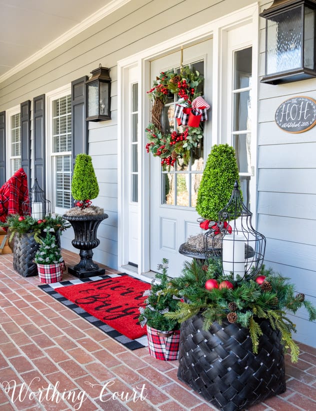 Front porch decorated for Christmas with red and green.