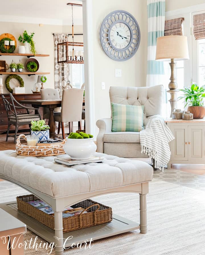 Family room decorated with neutral decor and pops of green plants.