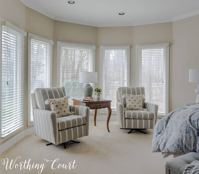 A neutral room with two armchairs and pillows.