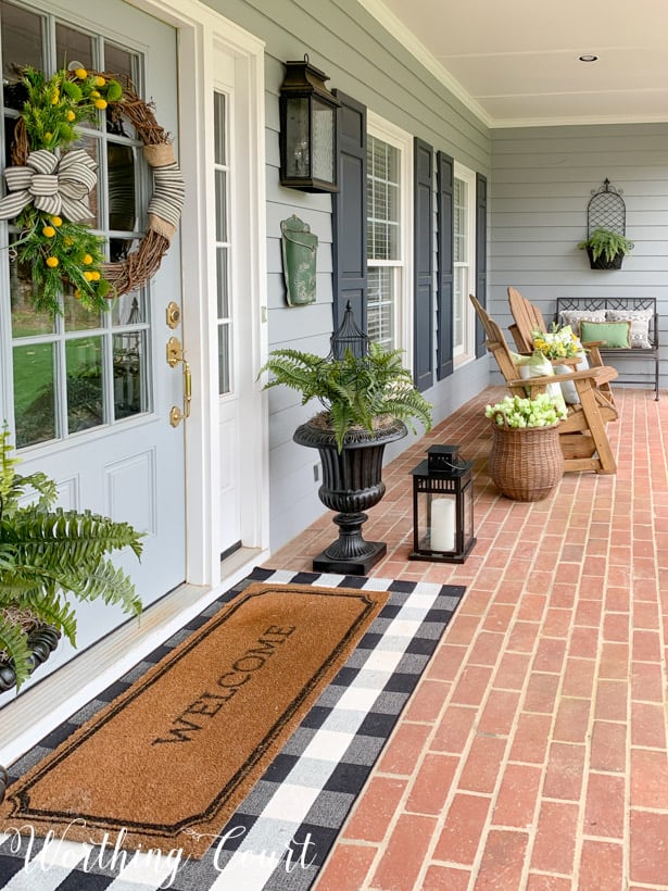 A welcome mat is at the front door of the house.