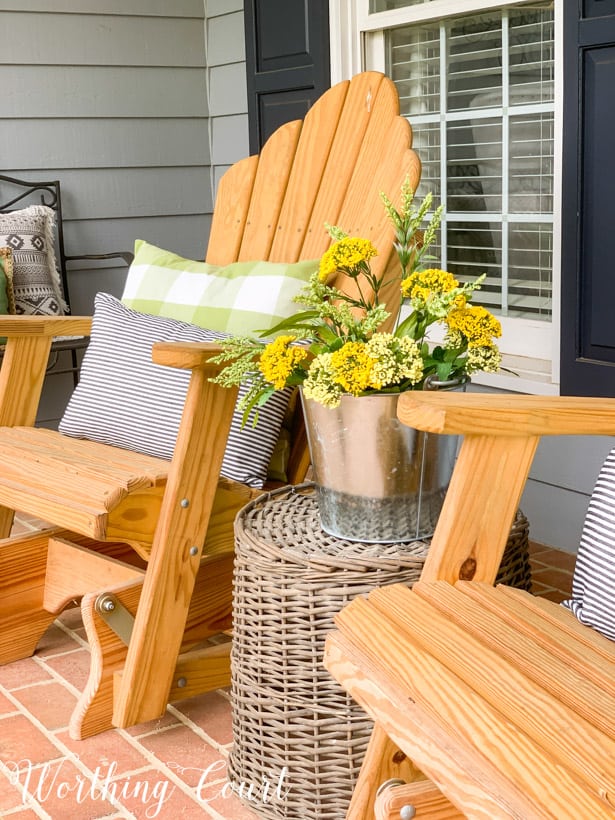 Front porch decorated for spring with an overturned basket used as a table.