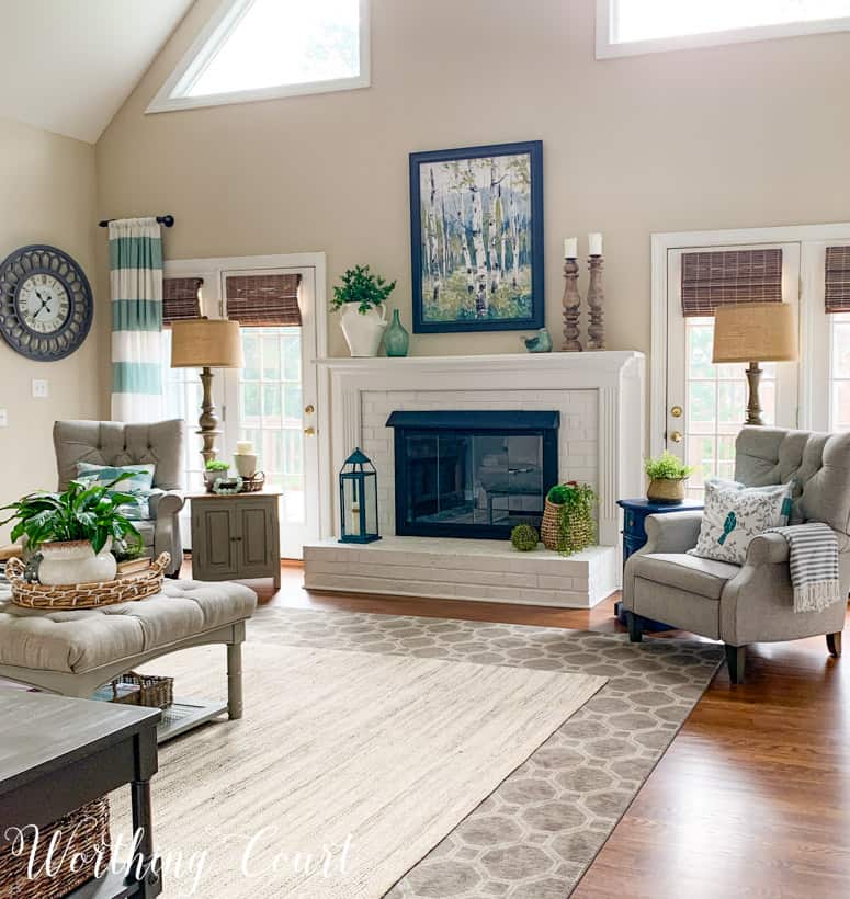 fireplace decorated for spring flanked by two gray chairs