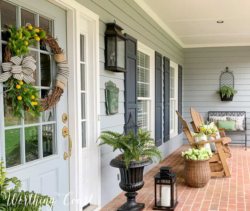 On the end of the porch there is a chair with neutral cushions on it.