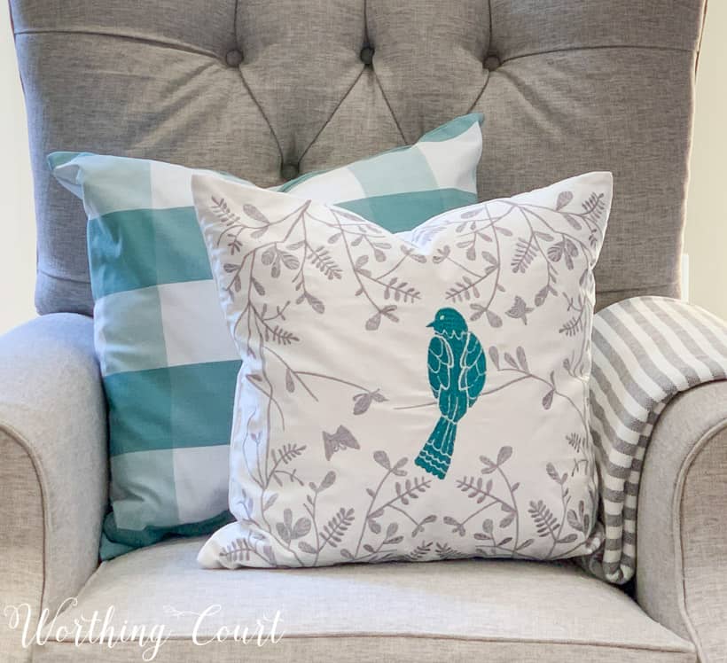 two blue and white spring pillows on a gray chair