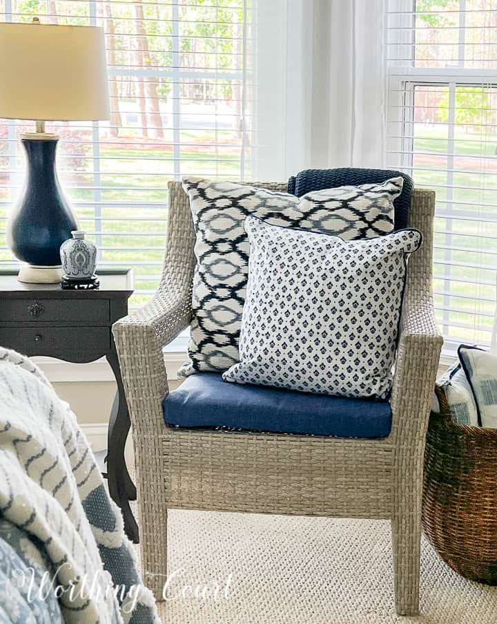 wicker look chair with blue pillows
