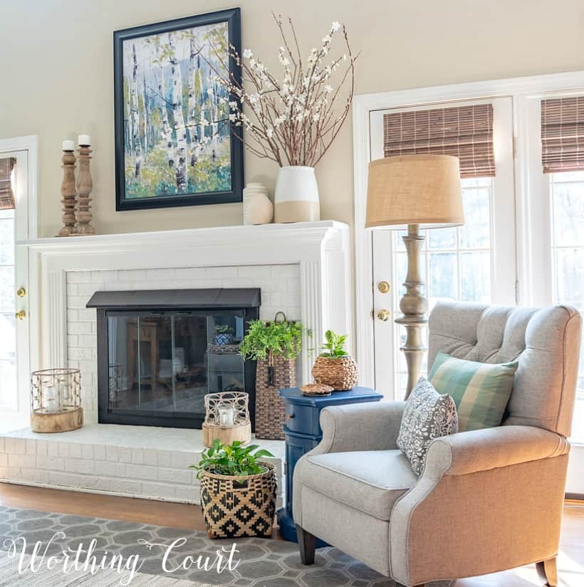 Gray recliner beside white painted brick fireplace.