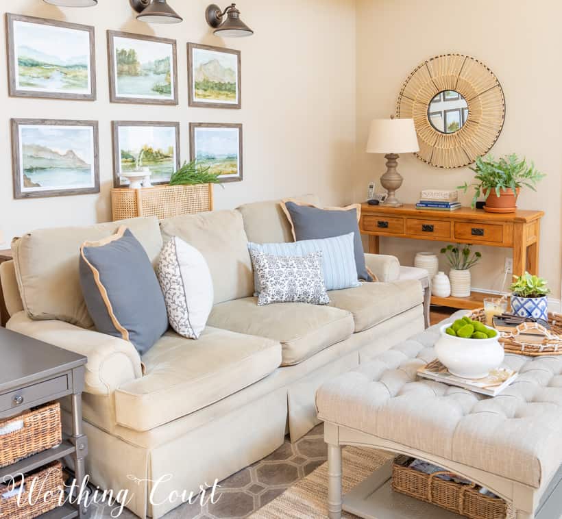 Sofa with gallery wall above and sofa tableland blue throw pillows on the couch.