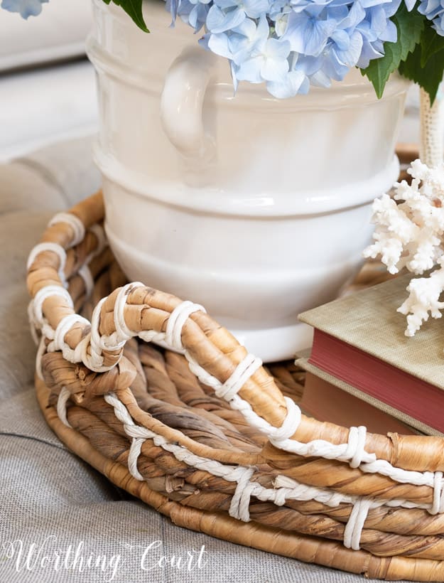 Wicker tray on a coffee table containing a summer vignette.