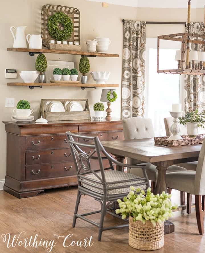 dining area with sideboard with open shelves above decorated with green and white accessories