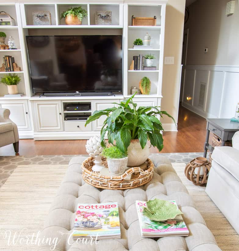 upholstered coffee table and white entertainment center with accessories