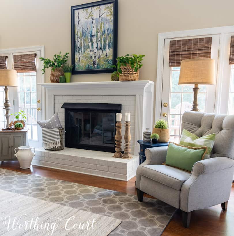 white brick fireplace with art, plants and baskets flanked by two recliners