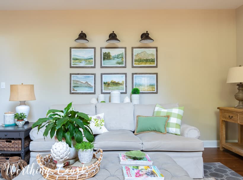 gray sofa with gallery wall above and upholstered coffee table