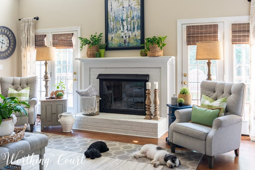 white brick fireplace with art, plants and baskets