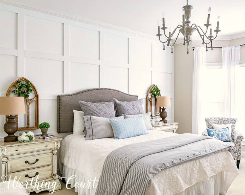 bed with gray headboard against white board and batten wall
