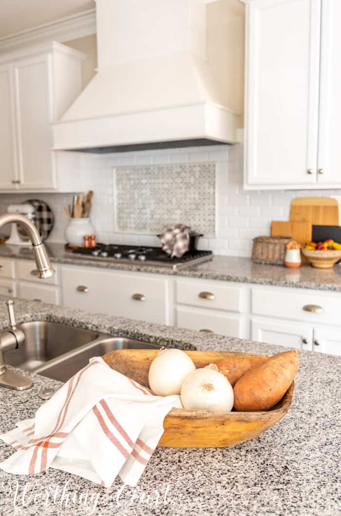 fall decor in kitchen with white cabinets and granite counters