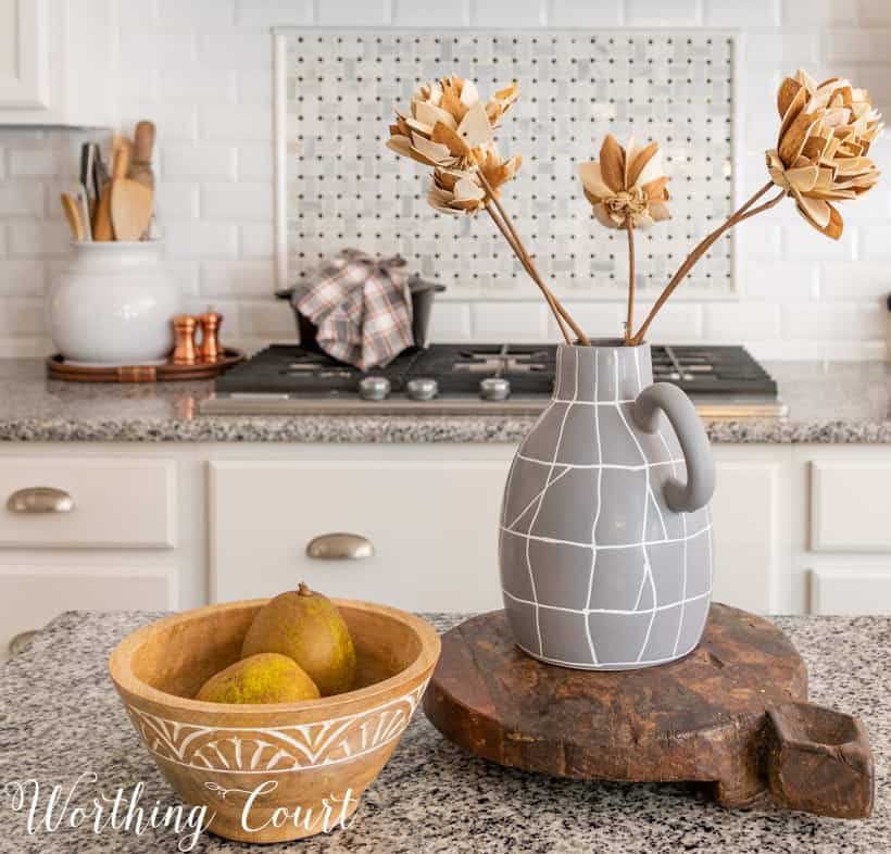 fall decor in kitchen with white cabinets and granite counters