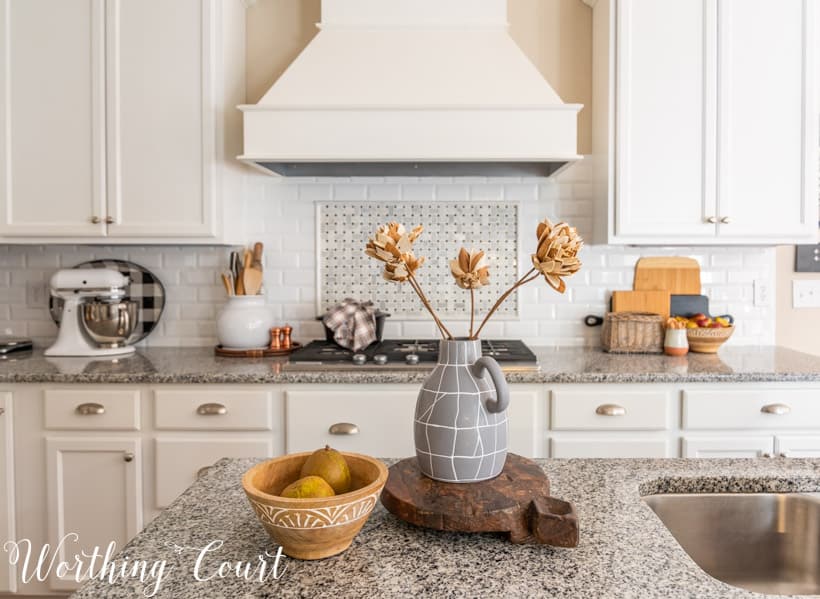 fall decor in kitchen with white cabinets and granite counters