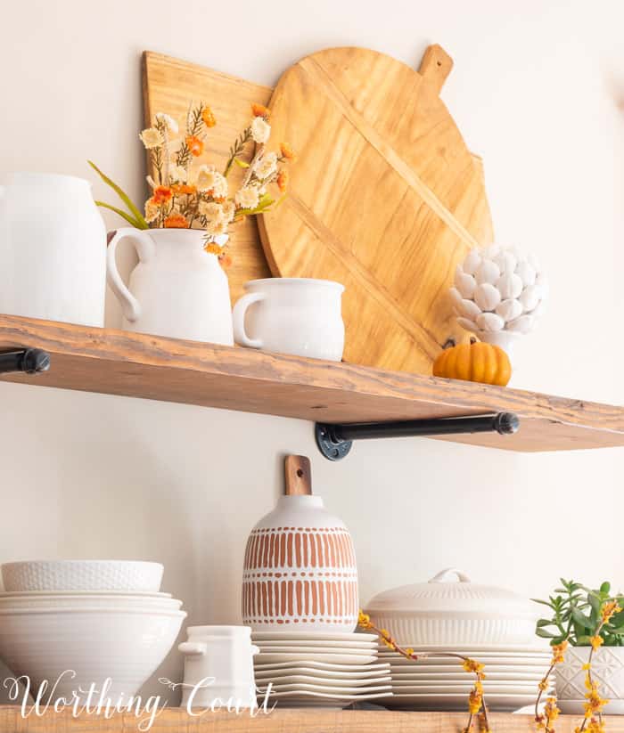 open shelves decorated for fall with white dishes