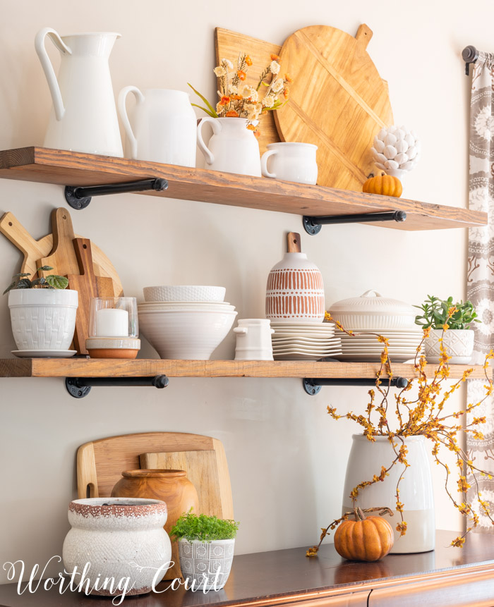 Open shelves decorated for fall with white dishes