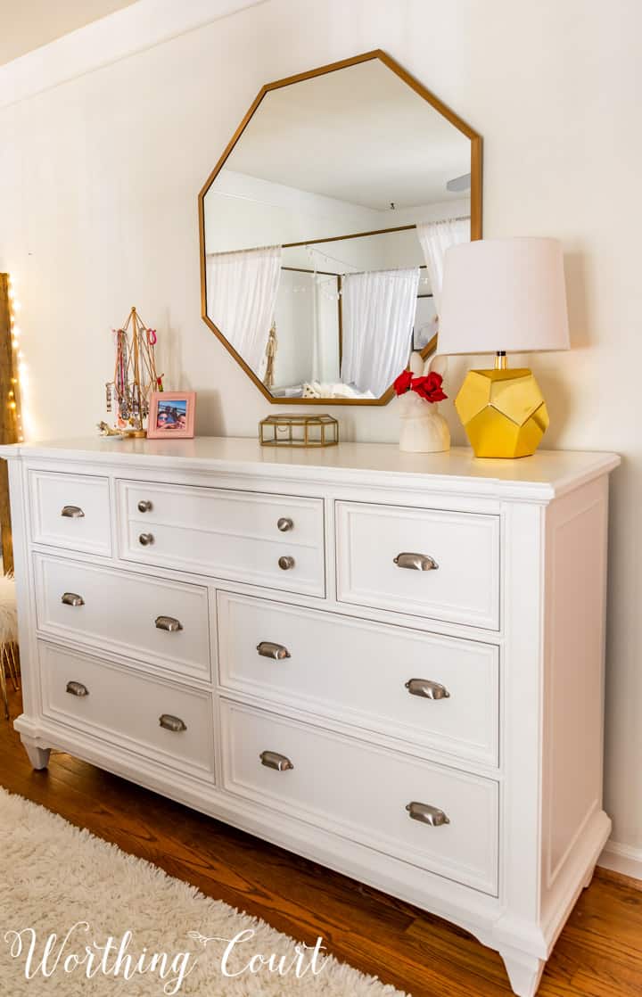 white dresser with octagonal mirror above