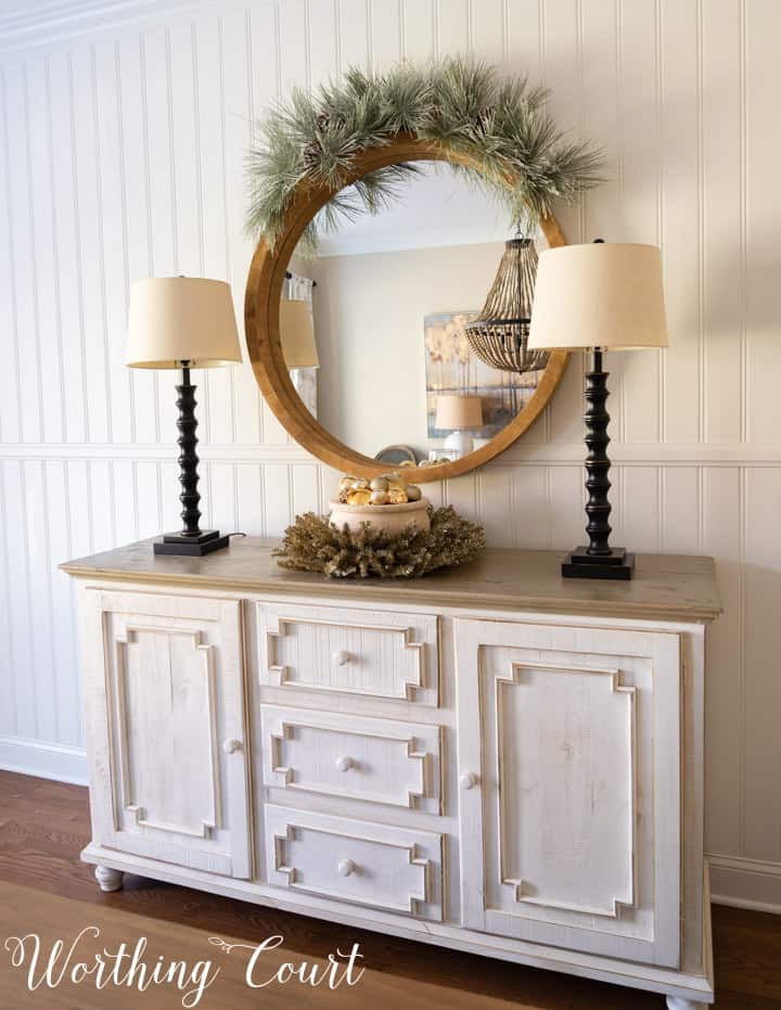 sideboard and round mirror decorated for Christmas