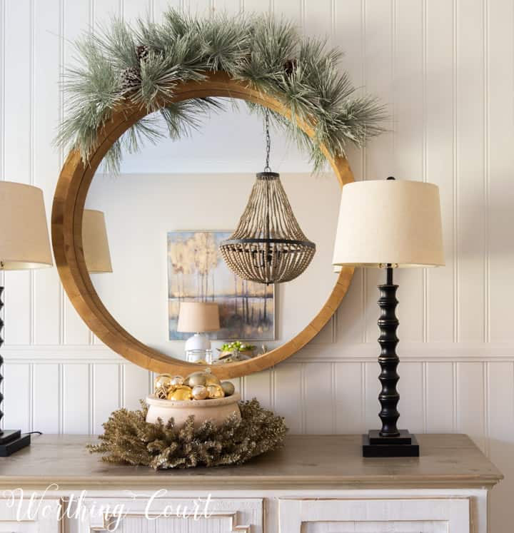 round mirror above sideboard with Christmas decorations