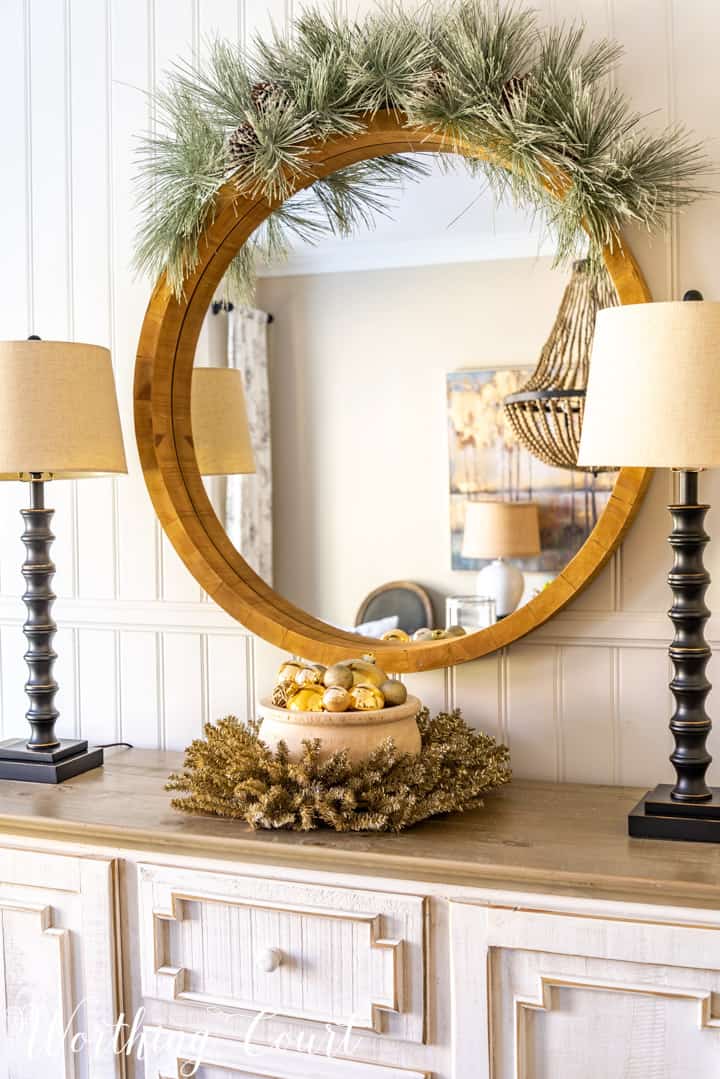 round mirror above sideboard with Christmas decorations