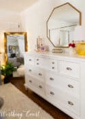 white dresser with octagonal mirror above