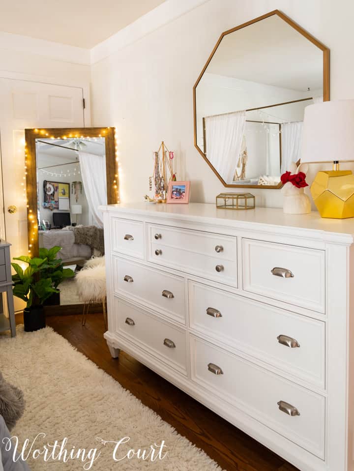 white dresser with octagonal mirror above