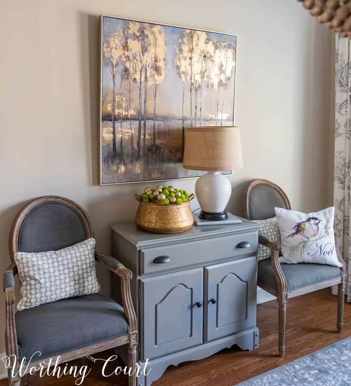 gray chest flanked by dining room chairs with artwork above
