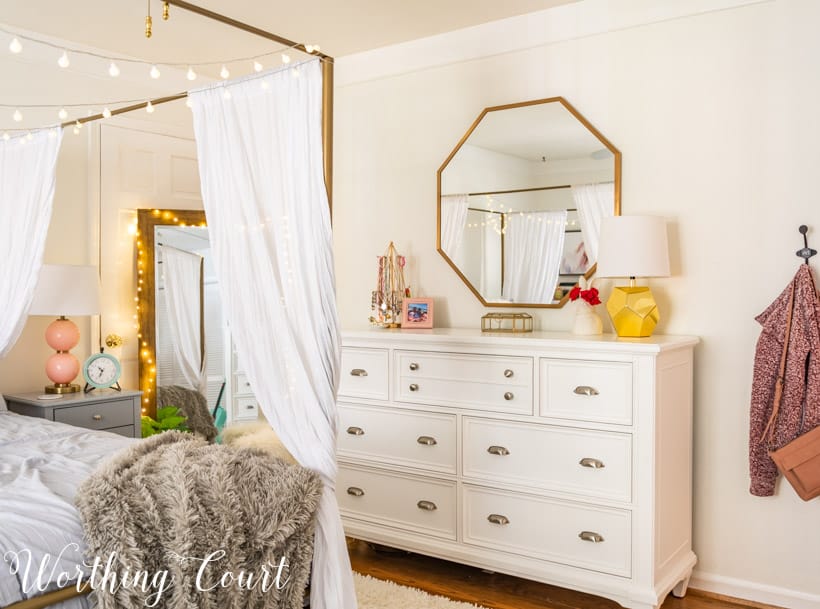 white dresser with octagonal mirror above