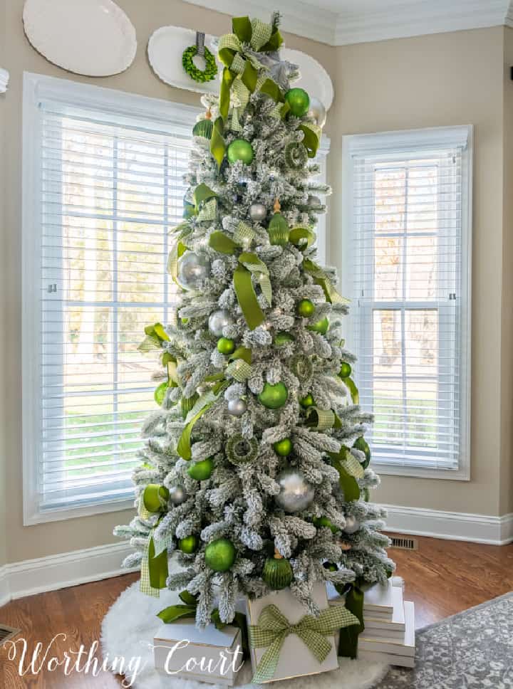 flocked Christmas tree with green and silver ornaments and ribbon