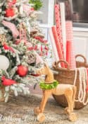 wooden horse beside flocked Christmas tree with red and white decorations