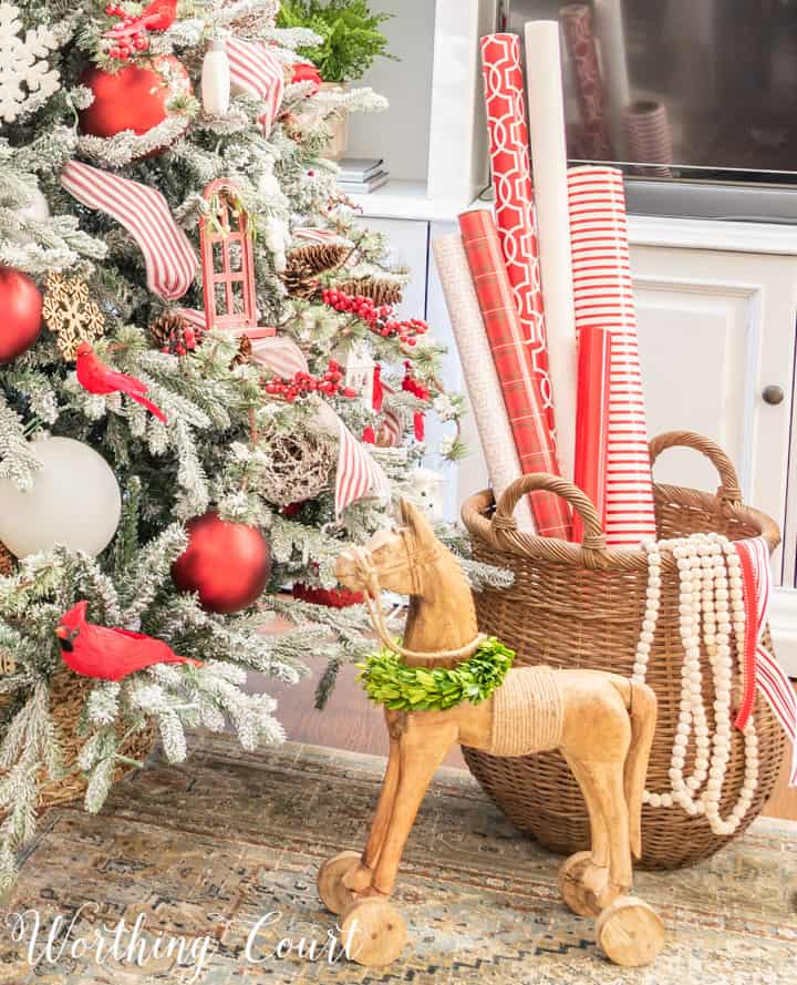 wooden horse beside flocked Christmas tree with red and white decorations
