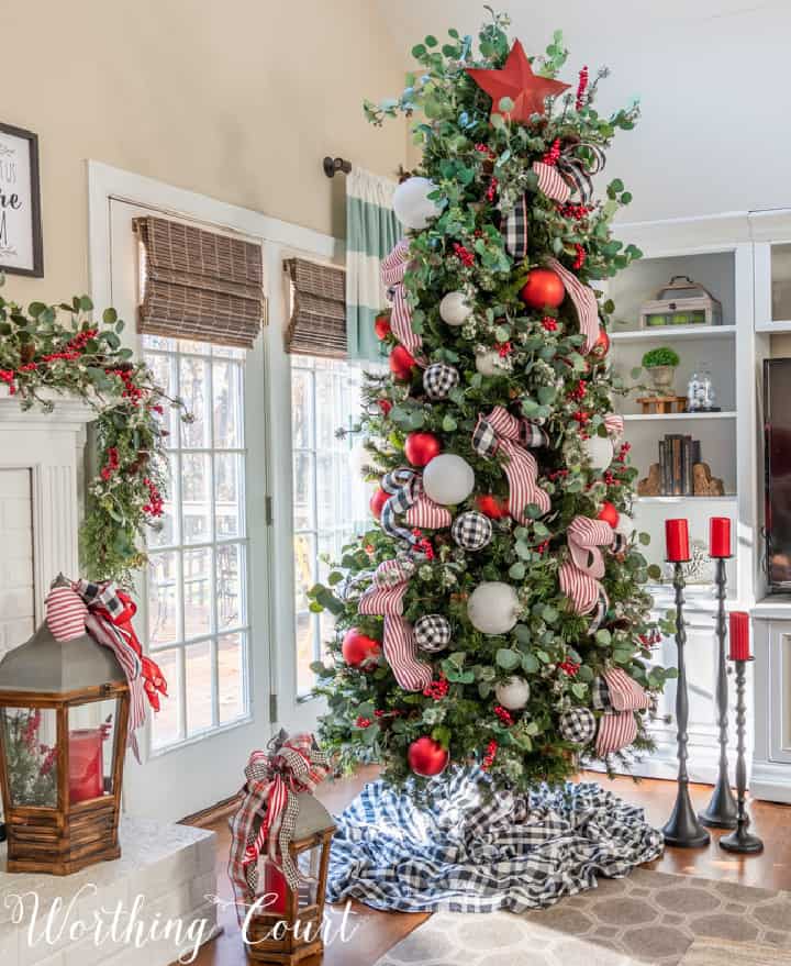 Christmas tree beside fireplace decorated with red, white and black