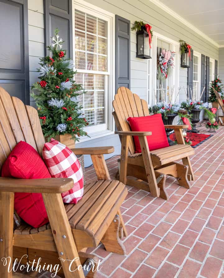 Adirondack chairs on porch with red and white pillows for Christmas